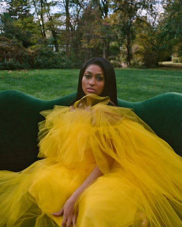 jazmine in yellow tulle dress on a green couch outside