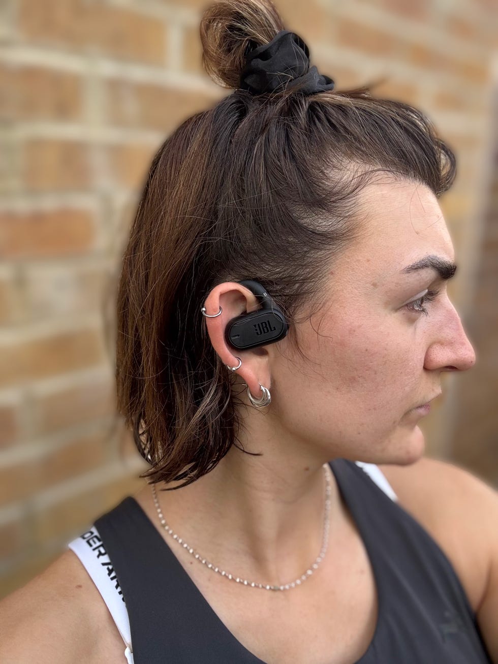 woman wearing the jbl soundgear sense earbuds