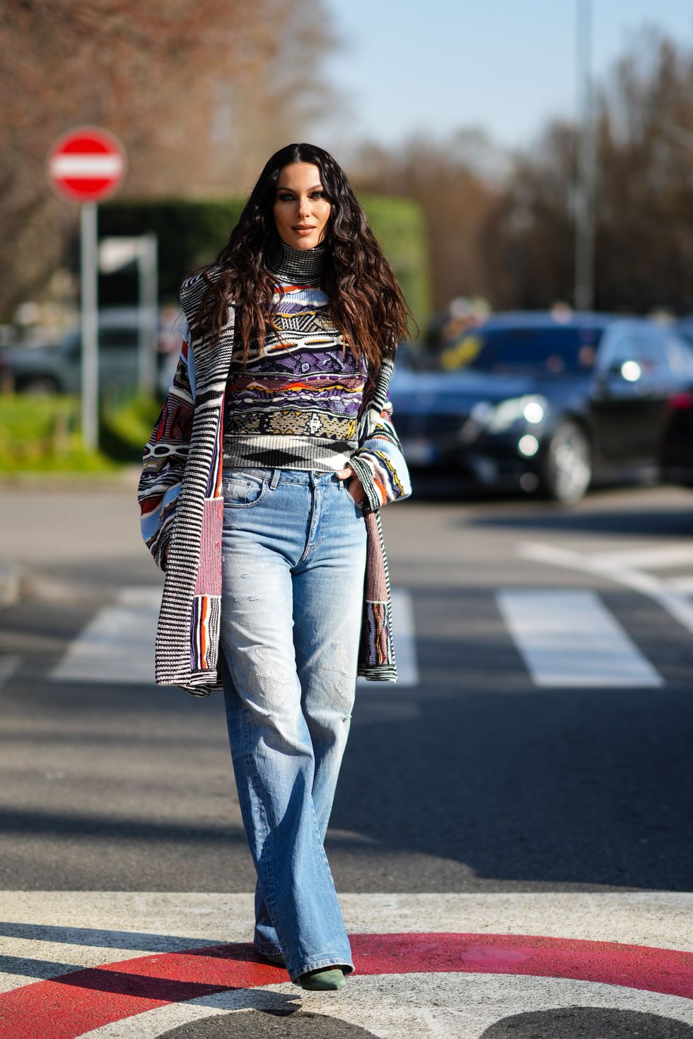 milan, italy   february 25 paola turani wears a gray  orange  purple  blue print pattern turtleneck pullover, a matching a gray  orange  purple  blue print pattern long wool cardigan, high waist blue faded flared denim jeans pants, green suede pointed pumps heels shoes, outside the missoni fashion show, during the milan fashion week fallwinter 20222023 on february 25, 2022 in milan, italy photo by edward berthelotgetty images