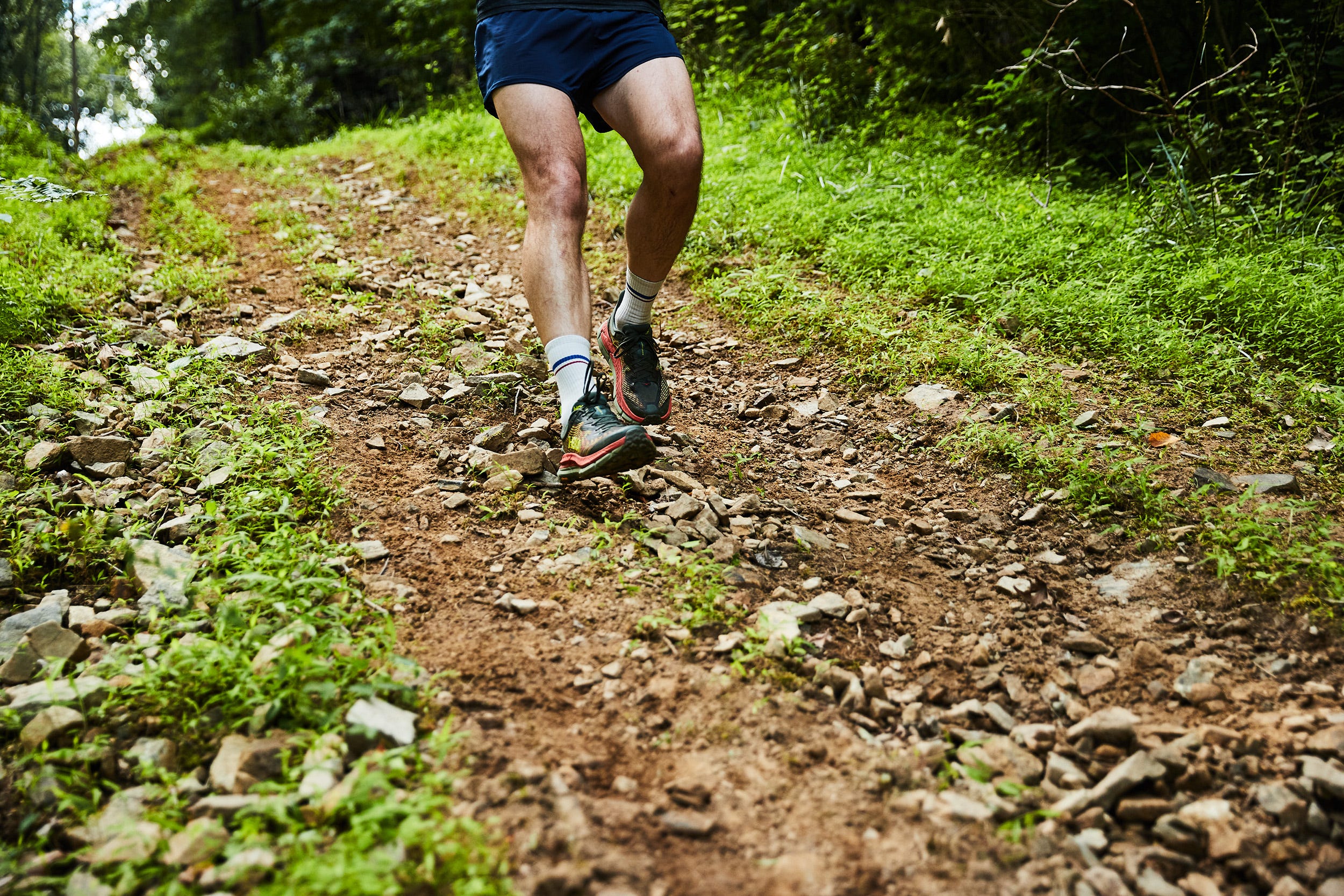a person running on a rocky hilly trail in hoka mafate speed 4 running shoes
