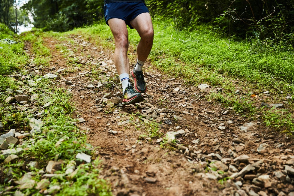 a person running on a rocky hilly trail in hoka mafate speed 4 running shoes