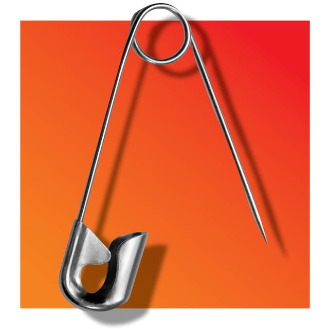 metal safety pin against a gradient background