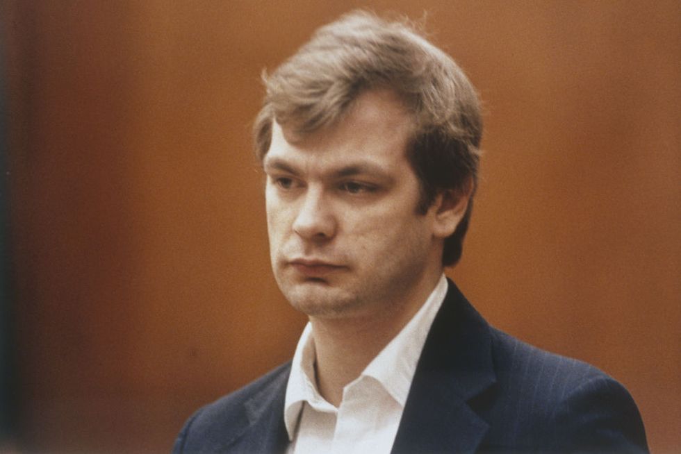 jeffrey dahmer, wearing a black suit jacket and white shirt, unsmiling, in a courtroom