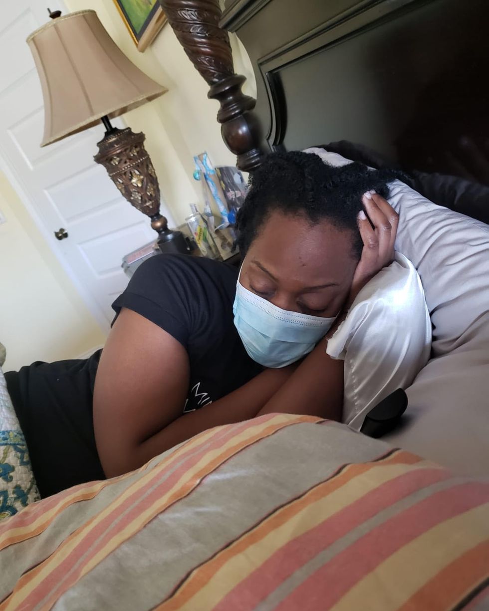 dr jehanne julien banica lays in bed with a face mask on
