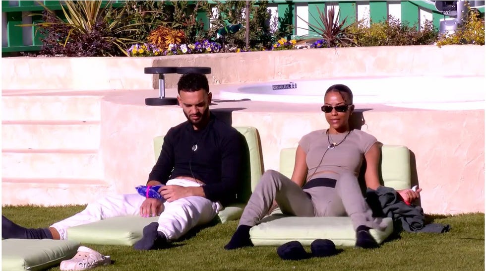 manuel cortes y jeimy baez hablan sentados en el suelo del patio de la casa de gh duo