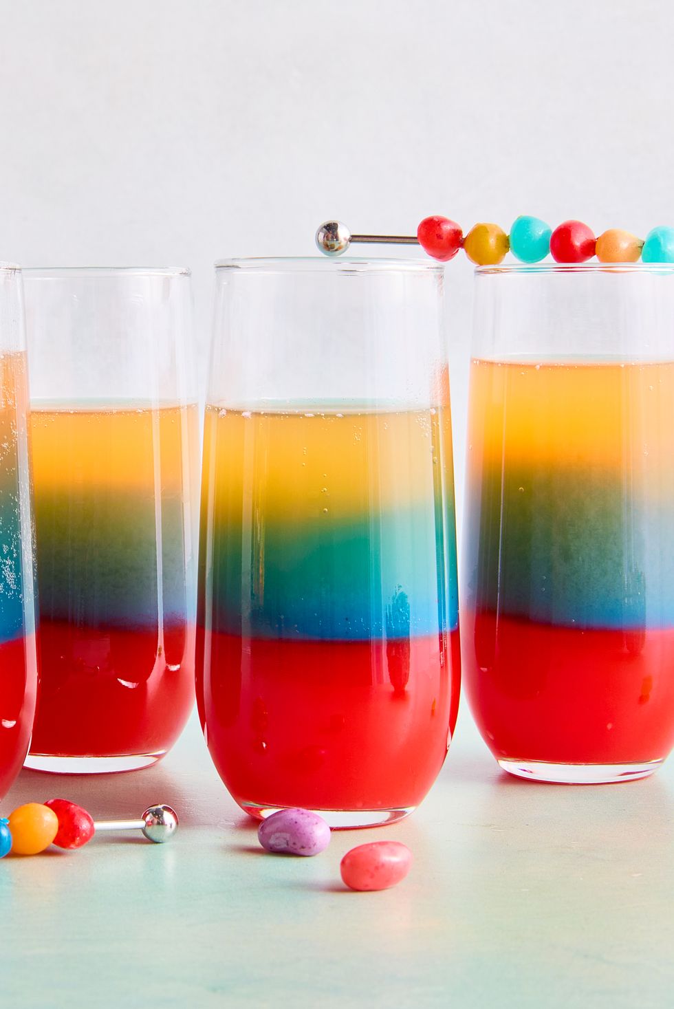 layered drink with red, blue, and orange topped with jelly beans