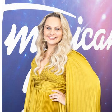 two individuals posing on a stage one with a colorful background and the other in a dramatic outfit two individuals posing on a stage one with a colorful background and the other in a dramatic outfit