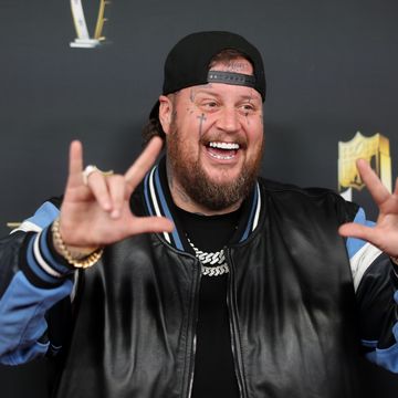 singer jelly roll poses for a photo against a black background