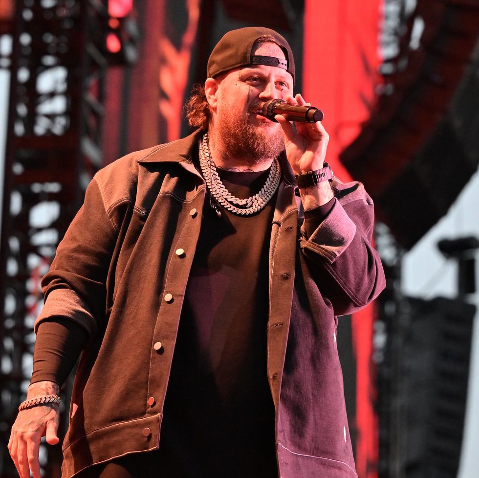 jelly roll singing in a microphone while standing on a stage