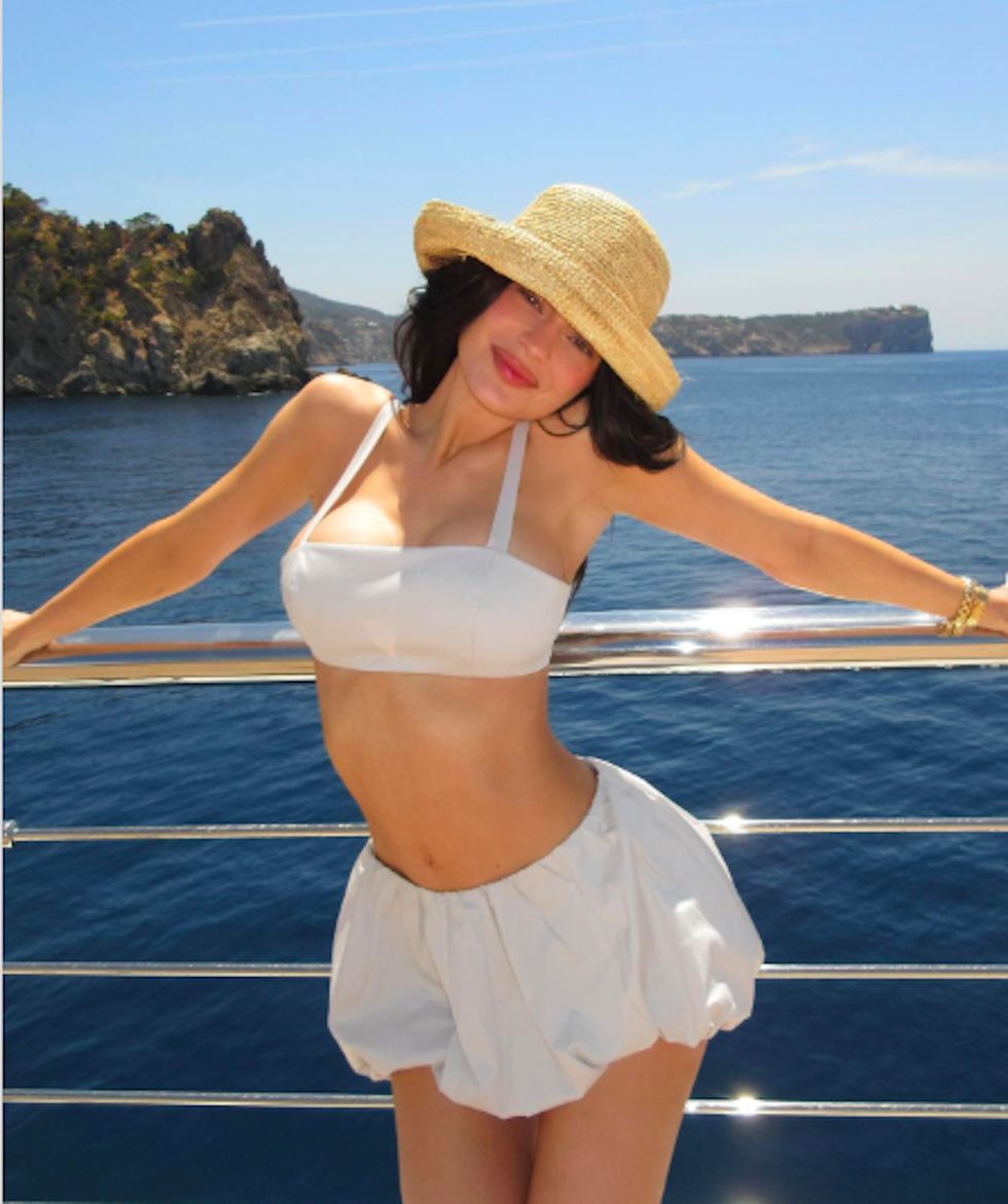 a woman wearing a hat and standing on a boat