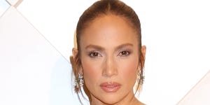 jennifer lopez poses in black strapless silk gown with her hair tied up