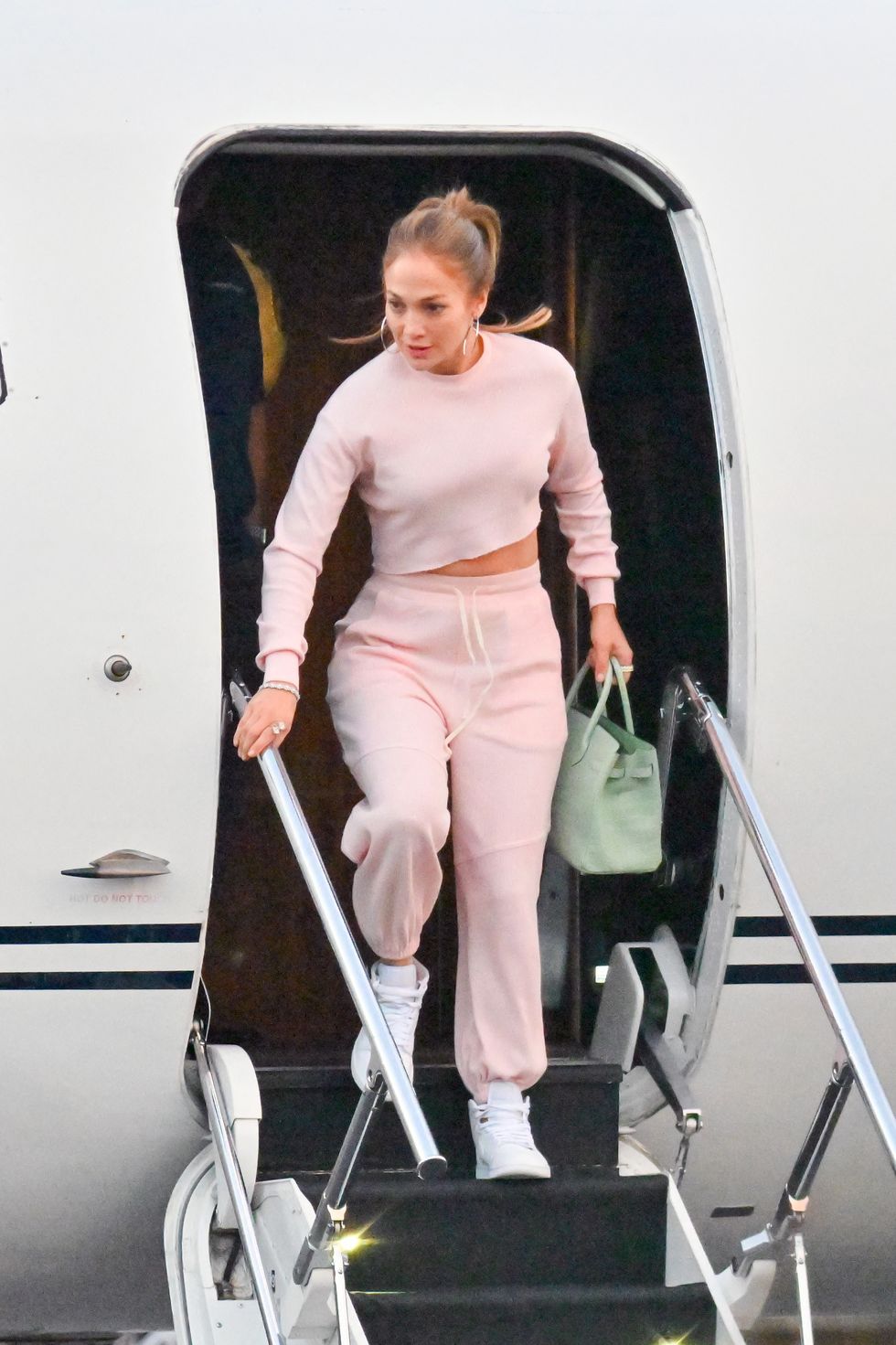 jennifer lopez leaving her private jet in a pink sweat suit