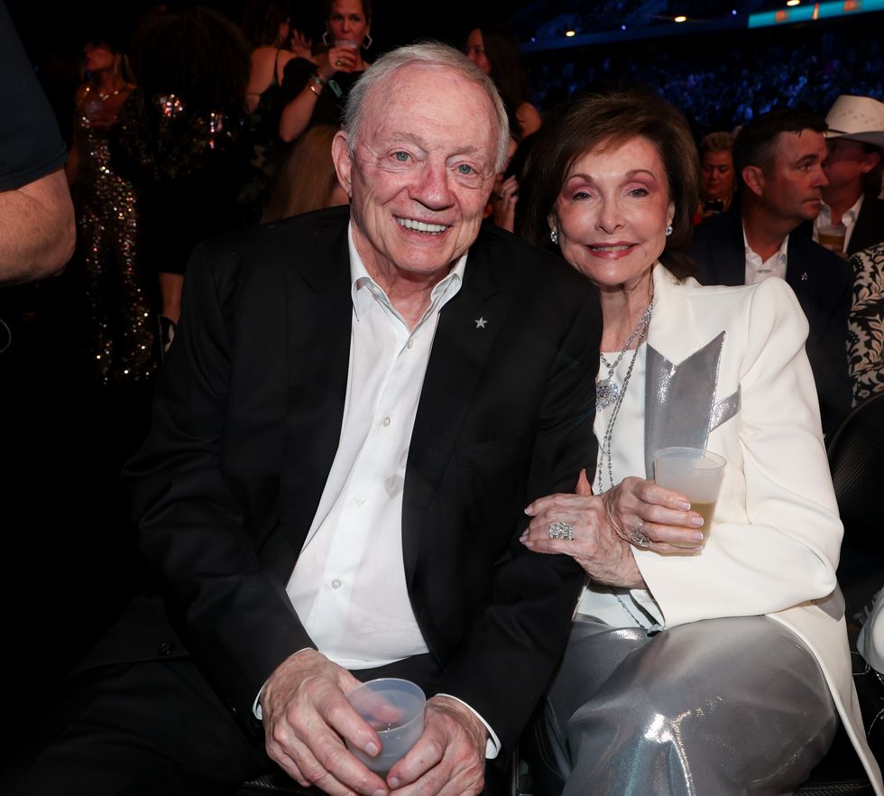 jerry jones and wife eugenia sitting amid a crowd of people and smiling