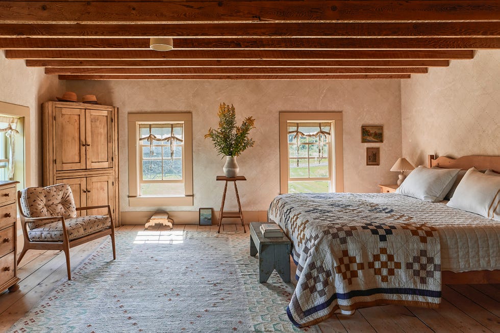 bedroom with bed with quilt on top and a wood hutch in the corner