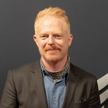 jesse tyler ferguson, a man stands looking at the camera smiling