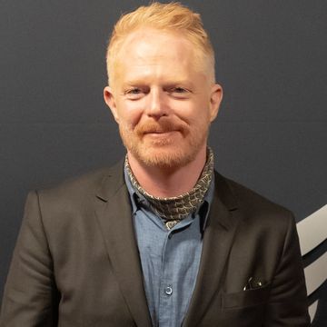 jesse tyler ferguson, a man stands looking at the camera smiling