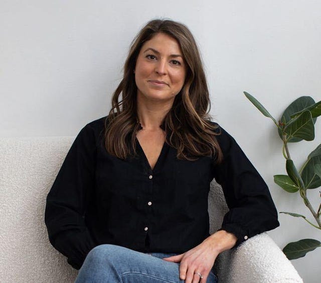 speaker jessica hann's headshot, pictured seated on a couch with white background