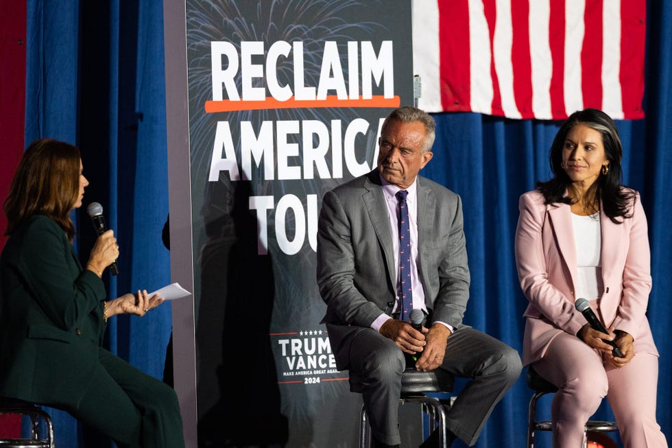 a panel discussion takes place on stage, featuring three individuals seated on stools