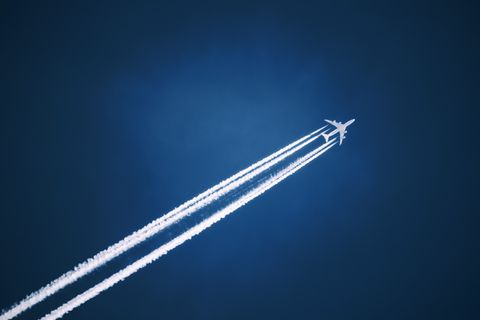 A jet vapour trail across a dark blue sky.