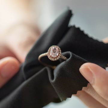 hands cleaning diamond ring with fabric cloth