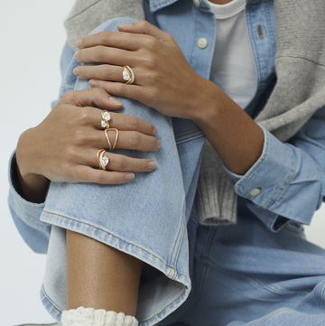a woman showing off her jewellery dressed in denim