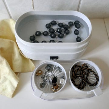 necklaces rings and earrings in jewelry cleaner with cleaning cloth