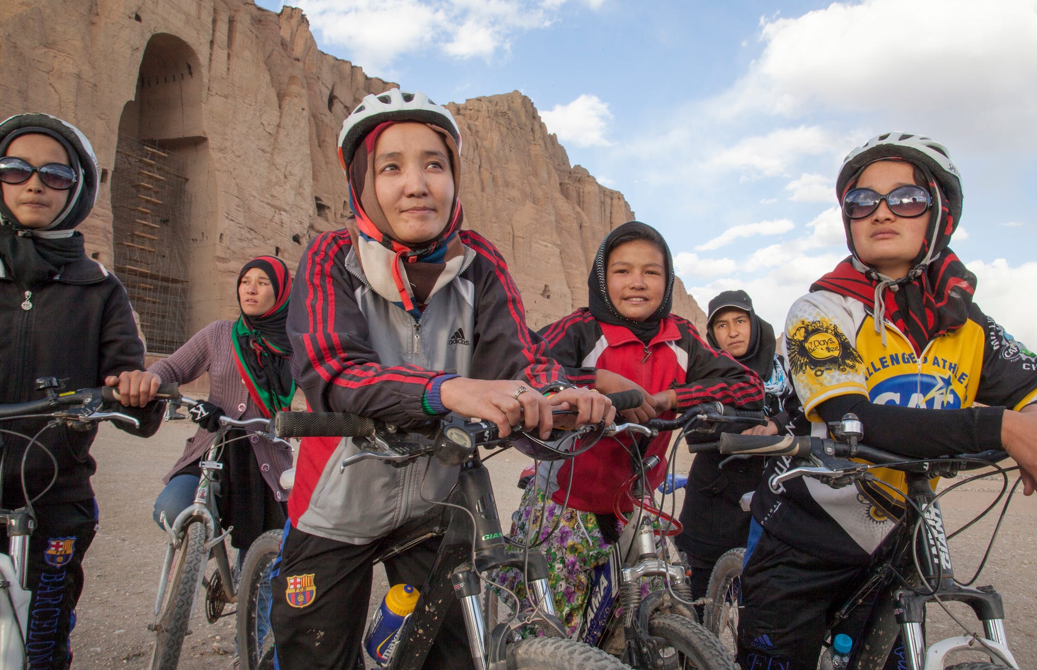 a group of women and girls with their bikes in a desert landscape