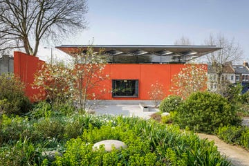 a red building surrounded by grassy plants