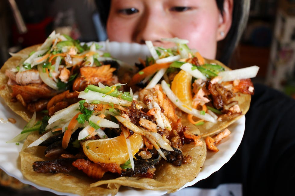 June holds a plate of salmon tacos topped with jicama slaw