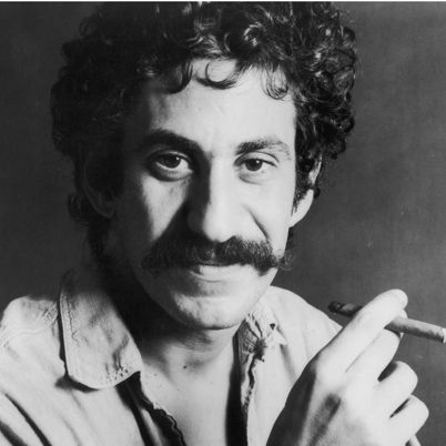 Headshot portrait of American singer-songwriter Jim Croce holding a cigar. His denim shirt is unbuttoned to reveal a tattoo and a chain with a bull's horn ornament.   (Photo by Hulton Archive/Getty Images)