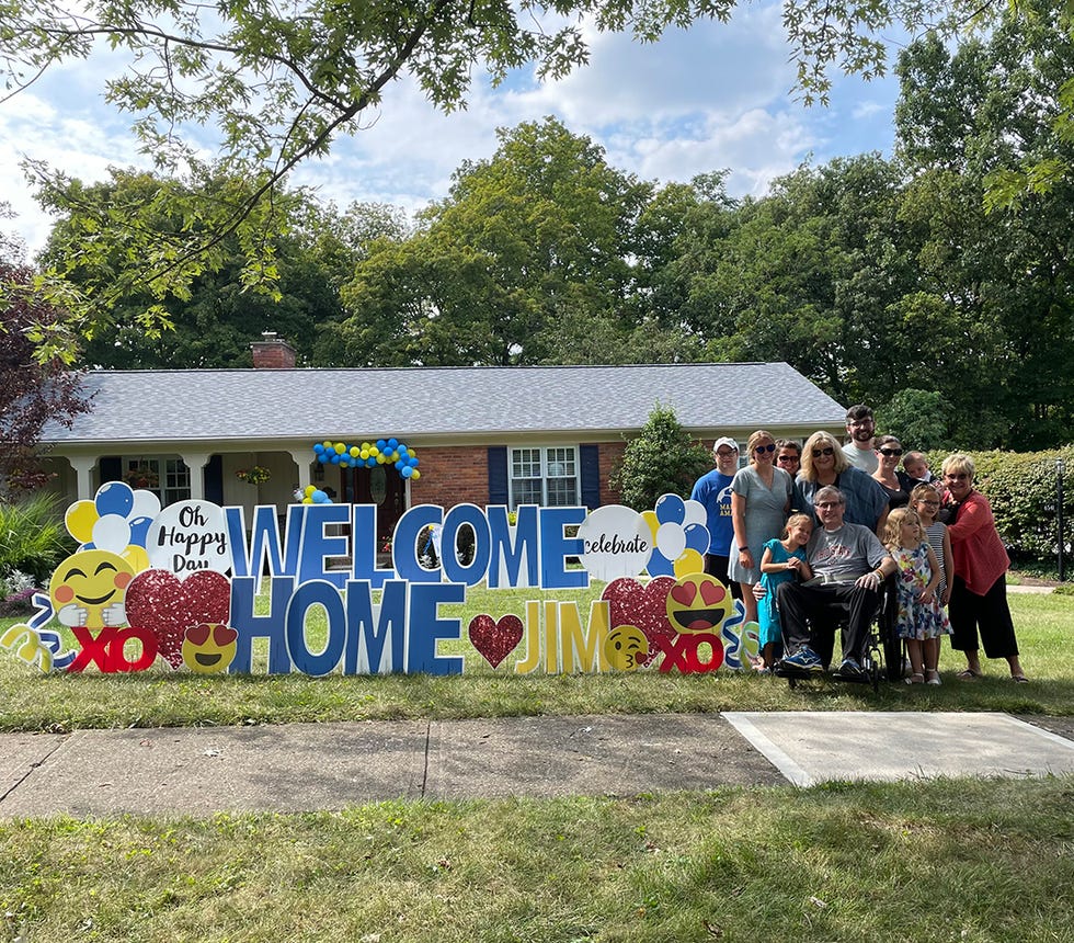 jim leblond and family with welcome home sign outside of their house