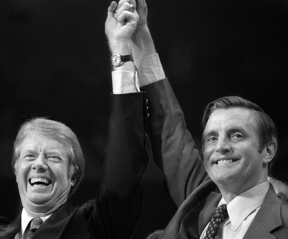 jimmy carter and walter mondale smiling and holding their hands in the air together
