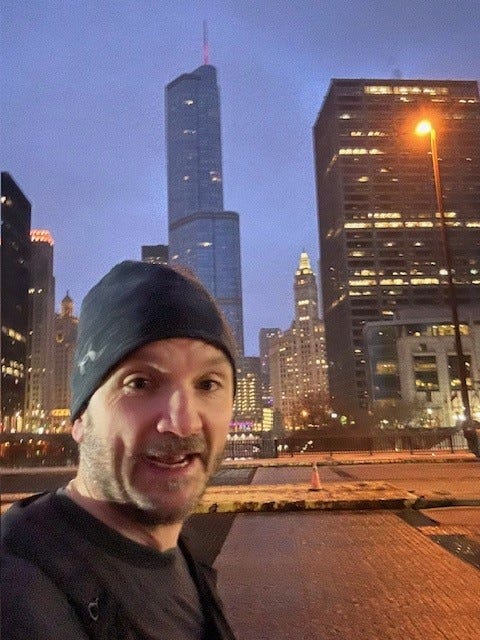 selfie taken in an urban setting with tall buildings and streetlights