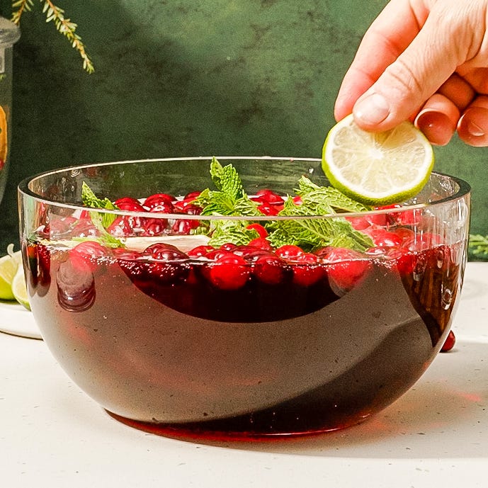 red holiday punch garnished with cranberries and lime