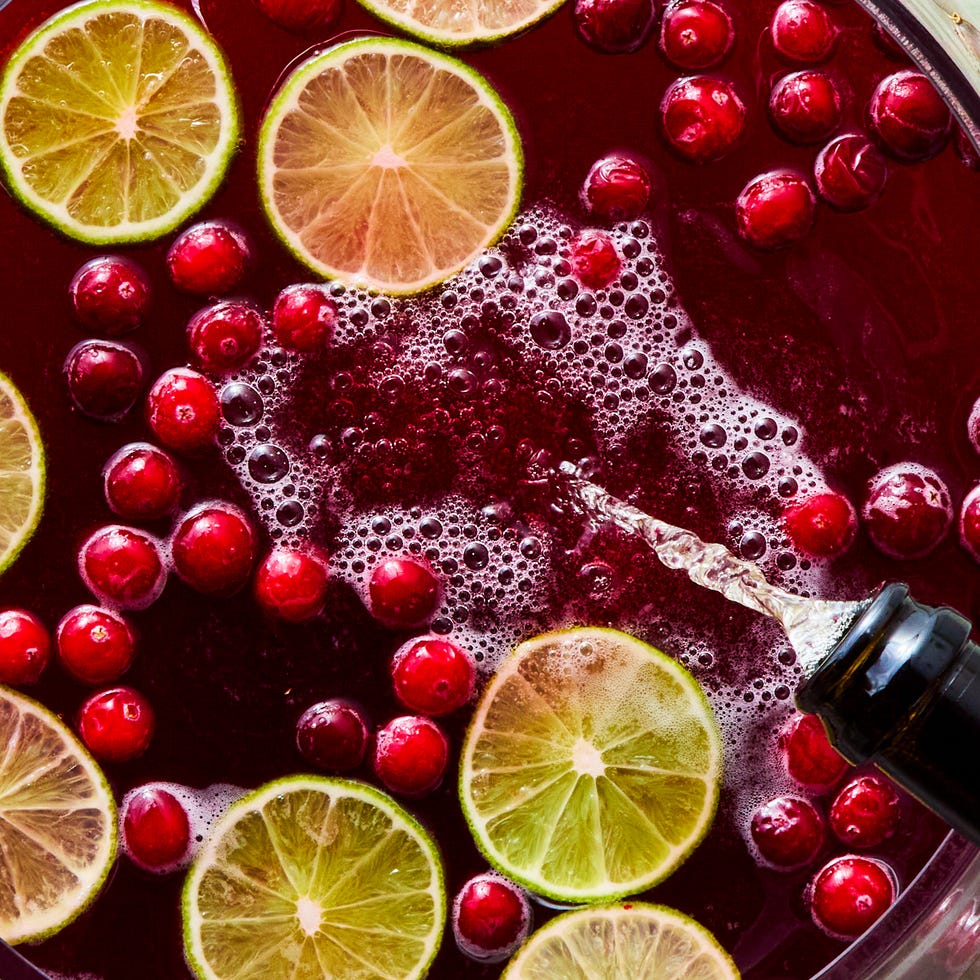 bowl of punch with cranberries and lime
