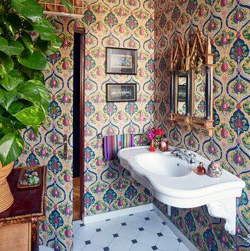 bathroom corner with white floating sink and wild patterned wallpaper