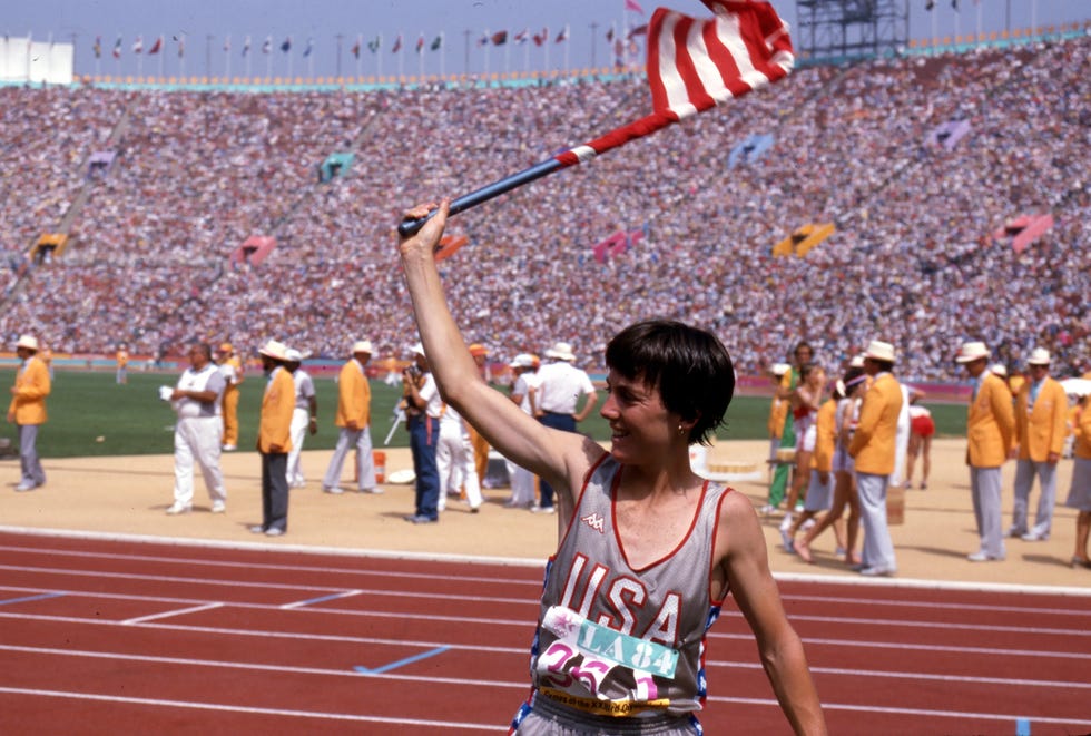 joan benoit celebra su triunfo en el maratón de los Ángeles 84 con la bandera de estados unidos