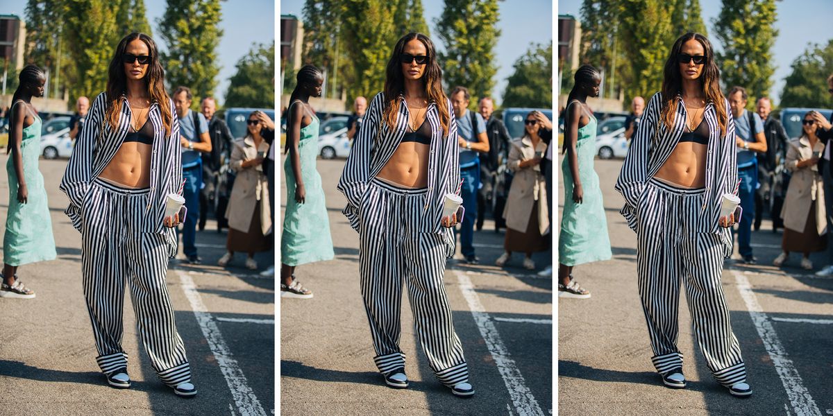 joan smalls wears striped pajamas outdoors in a roundup of the best pajamas for women 2022