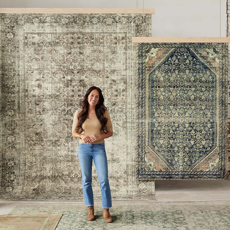 joanna gaines standing in front of vintage style rugs