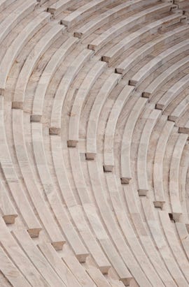 curved wooden seating arrangement with horizontal layers