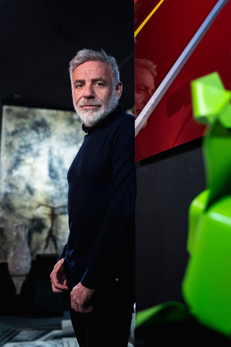 Joaquín Torres en su estudio de arquitectura posa apoyado en una pared de cristal de colores