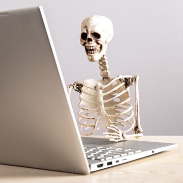 skelet zit achter laptop