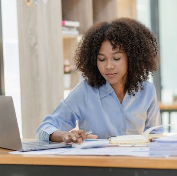 woman works on laptop as she calculates finances
