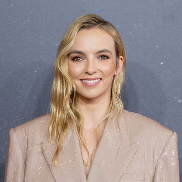 jodie comer smiles wearing a cream sequin suit at the last duel uk premiere at odeon luxe leicester square, london