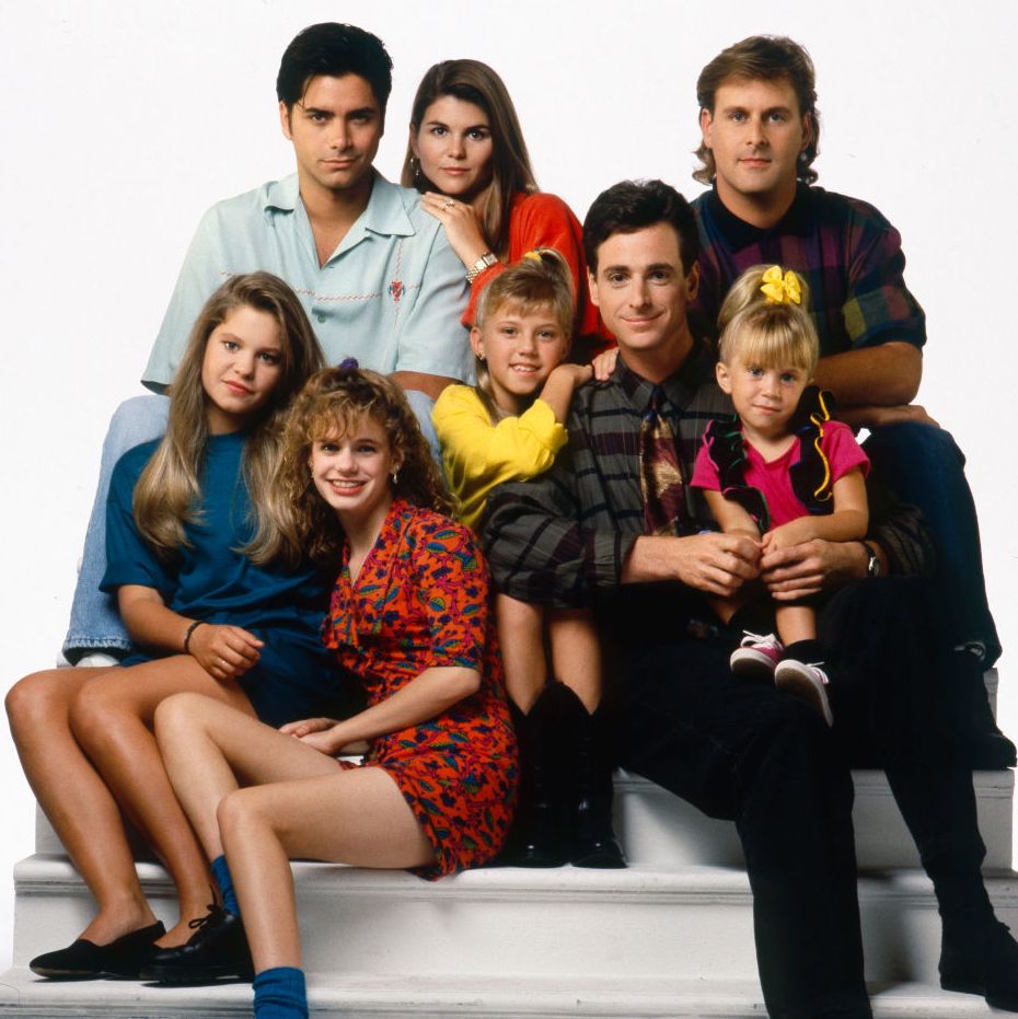 john stamos sitting for a cast photo with the actors of full house