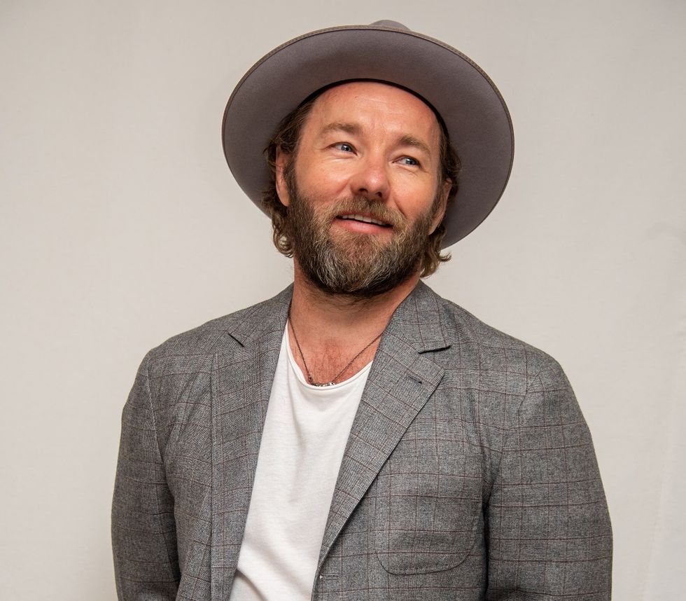 actor joel edgerton pictured in 2019, wearing a grey suit and hat