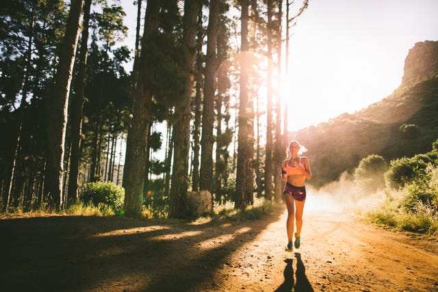 vrouw in korte sportkleding loopt hard in het bos