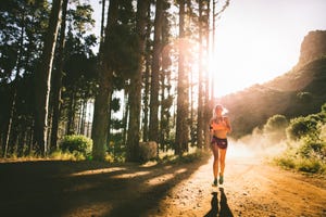 vrouw in korte sportkleding loopt hard in het bos