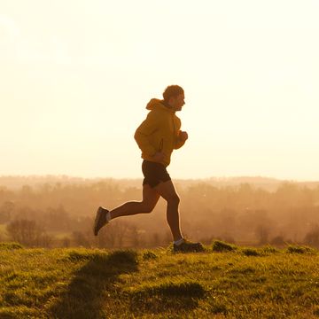 jogger running on hill at sunset