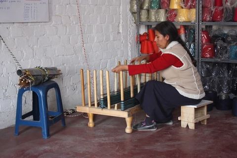 woman weaving on loom on stool